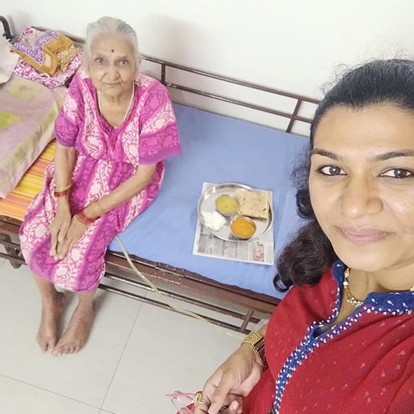 Dimple Oswal serving an old woman in an old age home